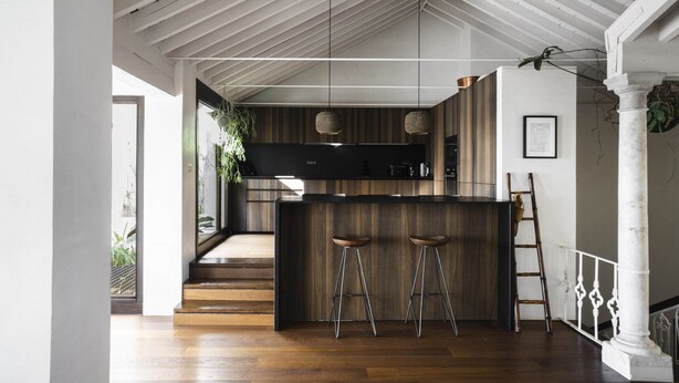 A modern kitchen with a wooden island, bar stools, and pendant lights. - Casa Porto with Sea View (Málaga)