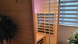 A room with a sliding wooden partition, a potted plant, and a window with blinds. - Room-terrace of the Friends of Visé (Vise)
