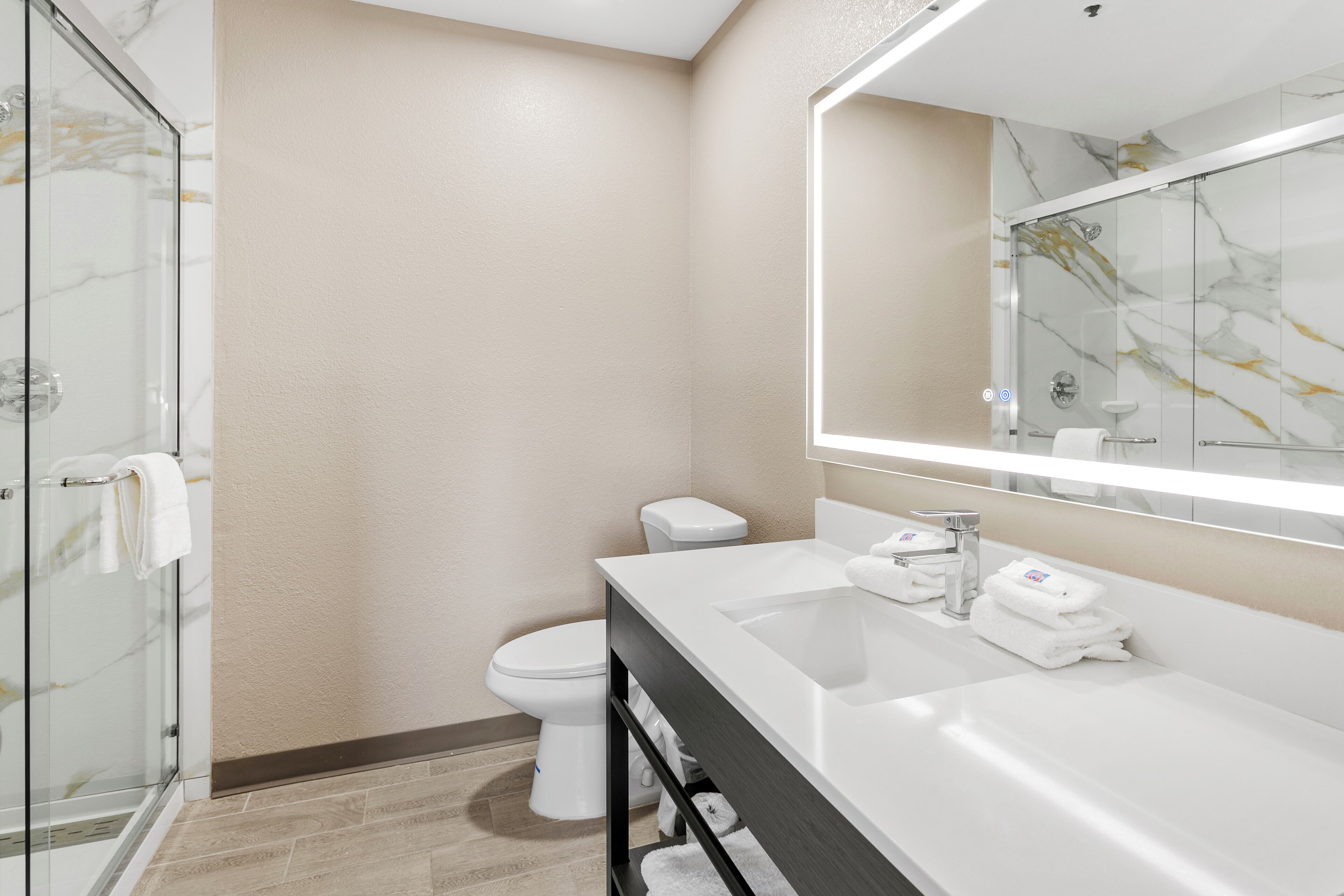 Kombinasi shower/bathtub, handuk, sabun, dan tisu toilet