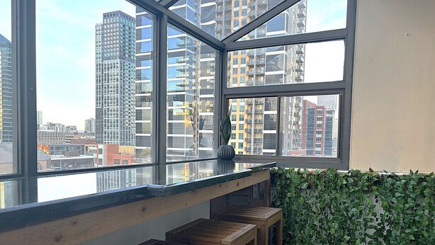 A high-rise building with a view of other buildings and a river. - Stylish DT Views at Stampede w/ Free Parking, AC (Calgary)