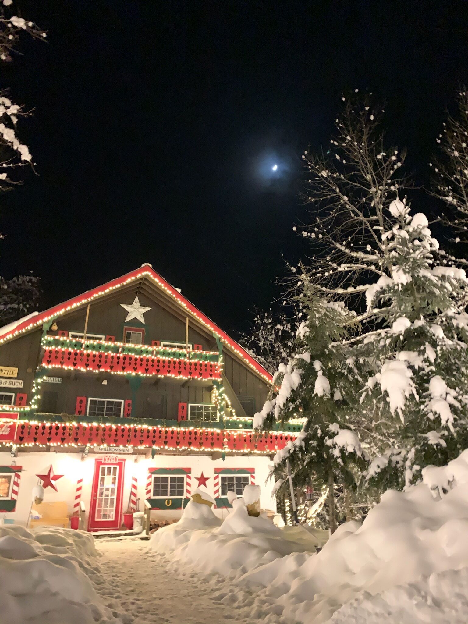 Ein Gebäude mit einem Stern auf dem Dach, umgeben von Schnee, und ein Mond am Himmel.