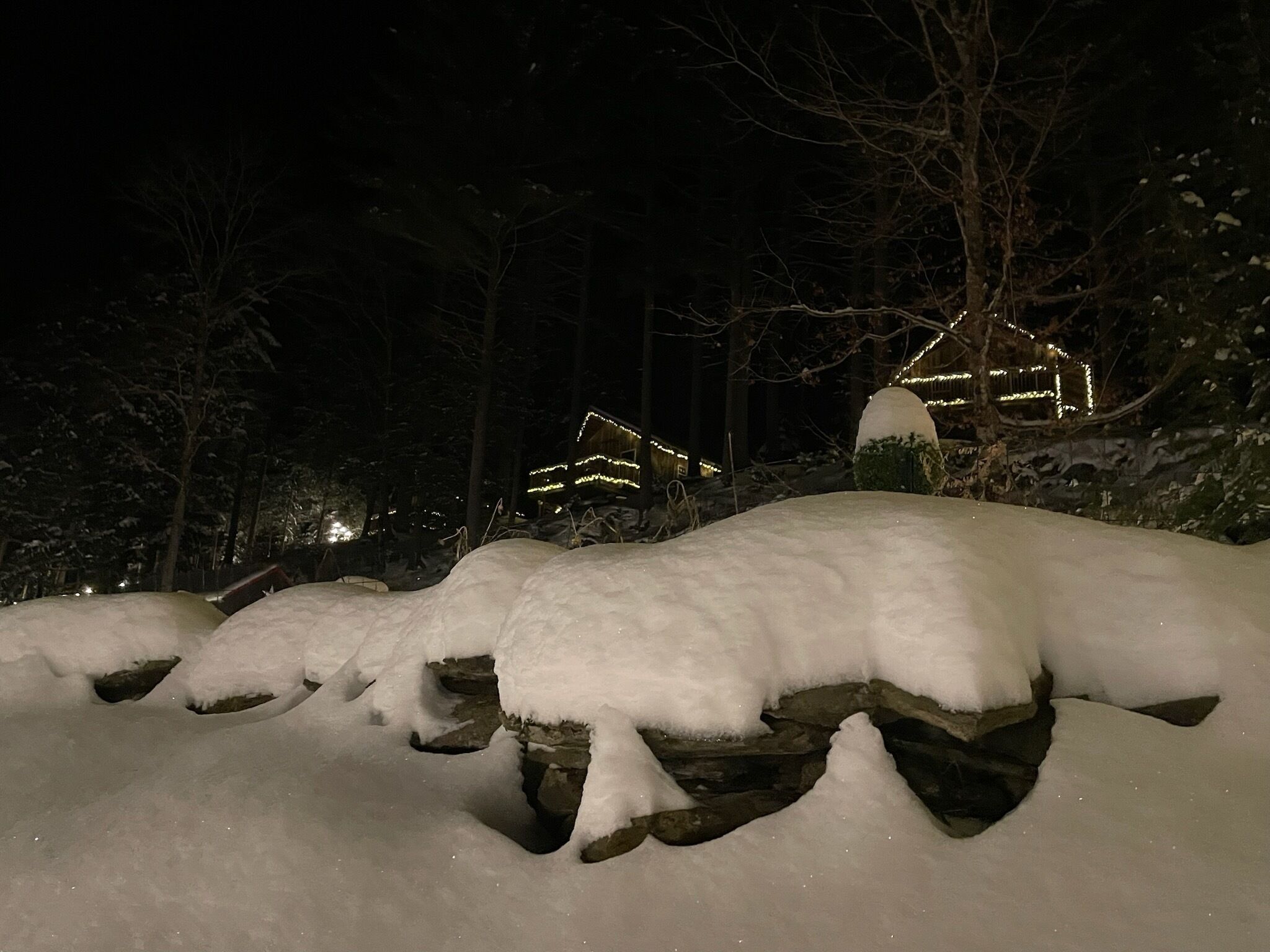 A snow-covered landscape with illuminated structures in the background.