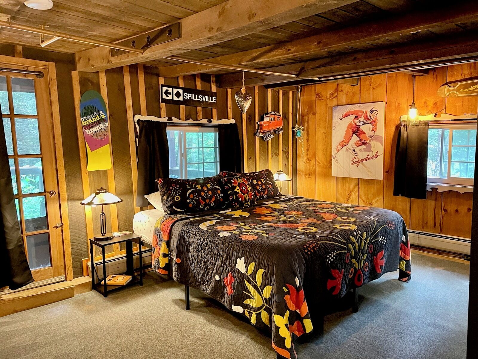 Ein gemütlicher Holzraum mit einem Bett, einem kleinen Tisch und einem Schild mit der Aufschrift 'Spillsville'.