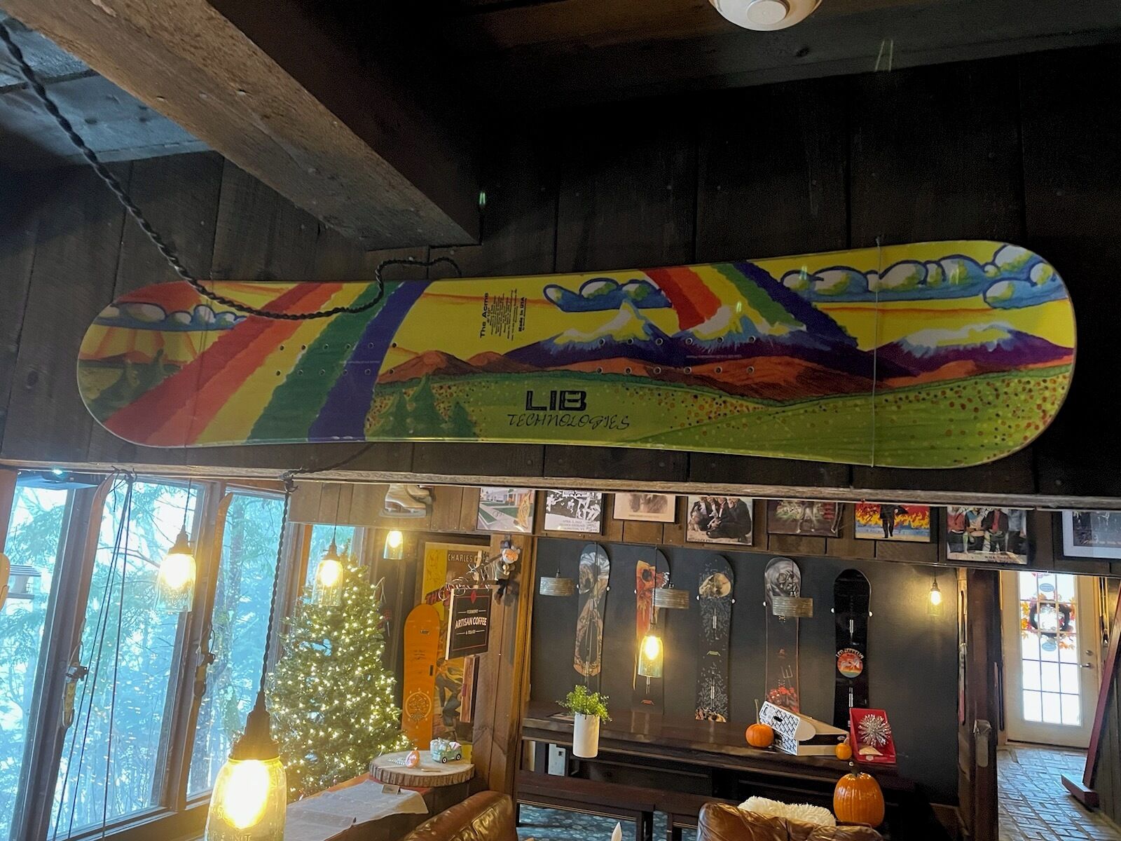 A cozy interior with a snowboard display, a Christmas tree, and various decorations.
