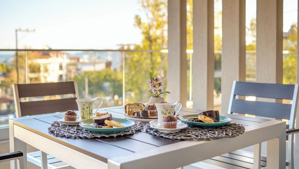 A table set for a meal with a view of buildings and trees in the background. - Aura Luxury Suites - Olympiada Cozy Getaways (Aristotelis)