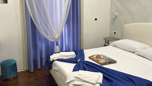 A neatly made bed with a blue blanket, a tray with food, and a white pillow. - B&B Giosuè (Naples)