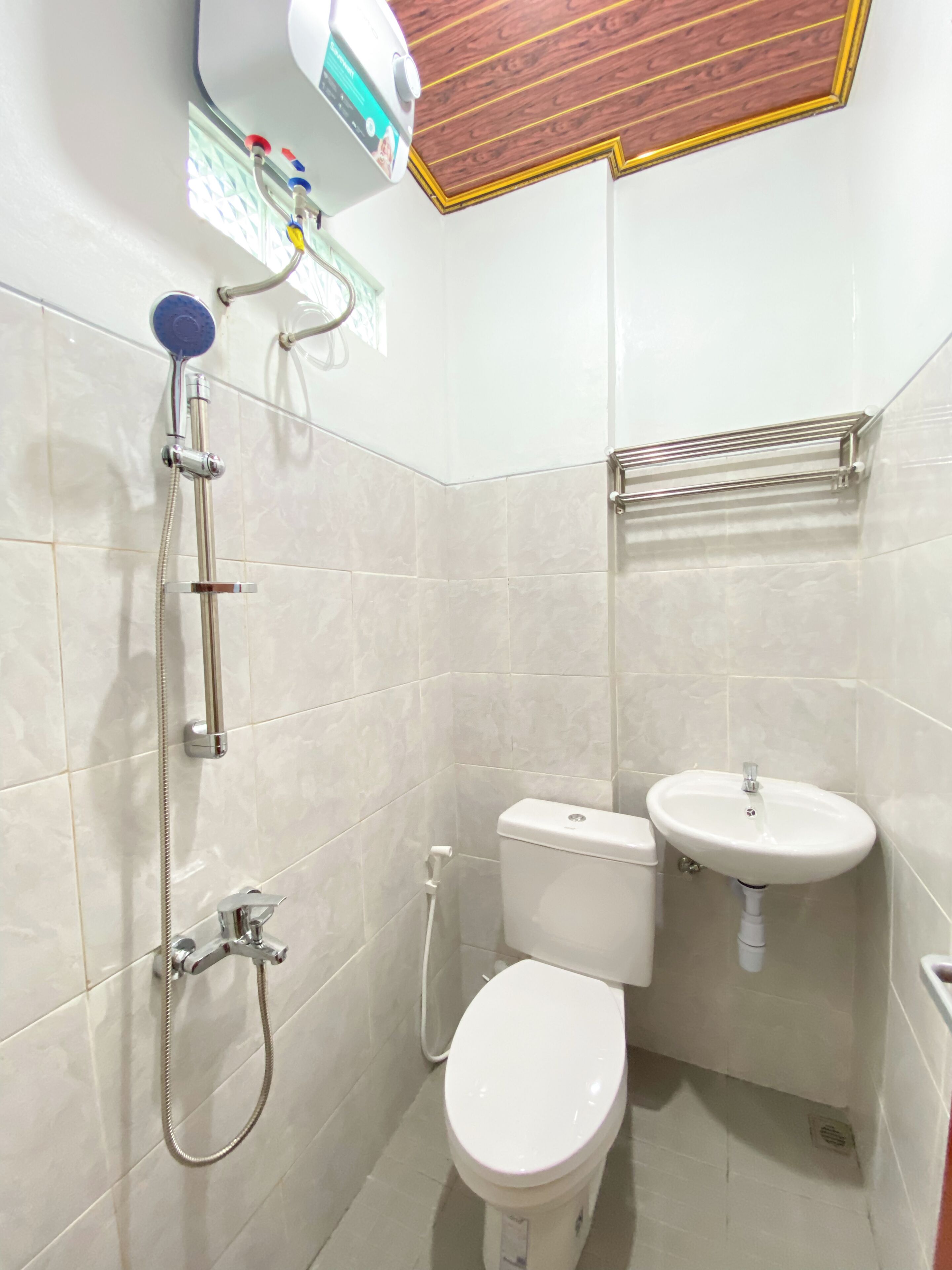A small bathroom with a toilet, sink, and shower.