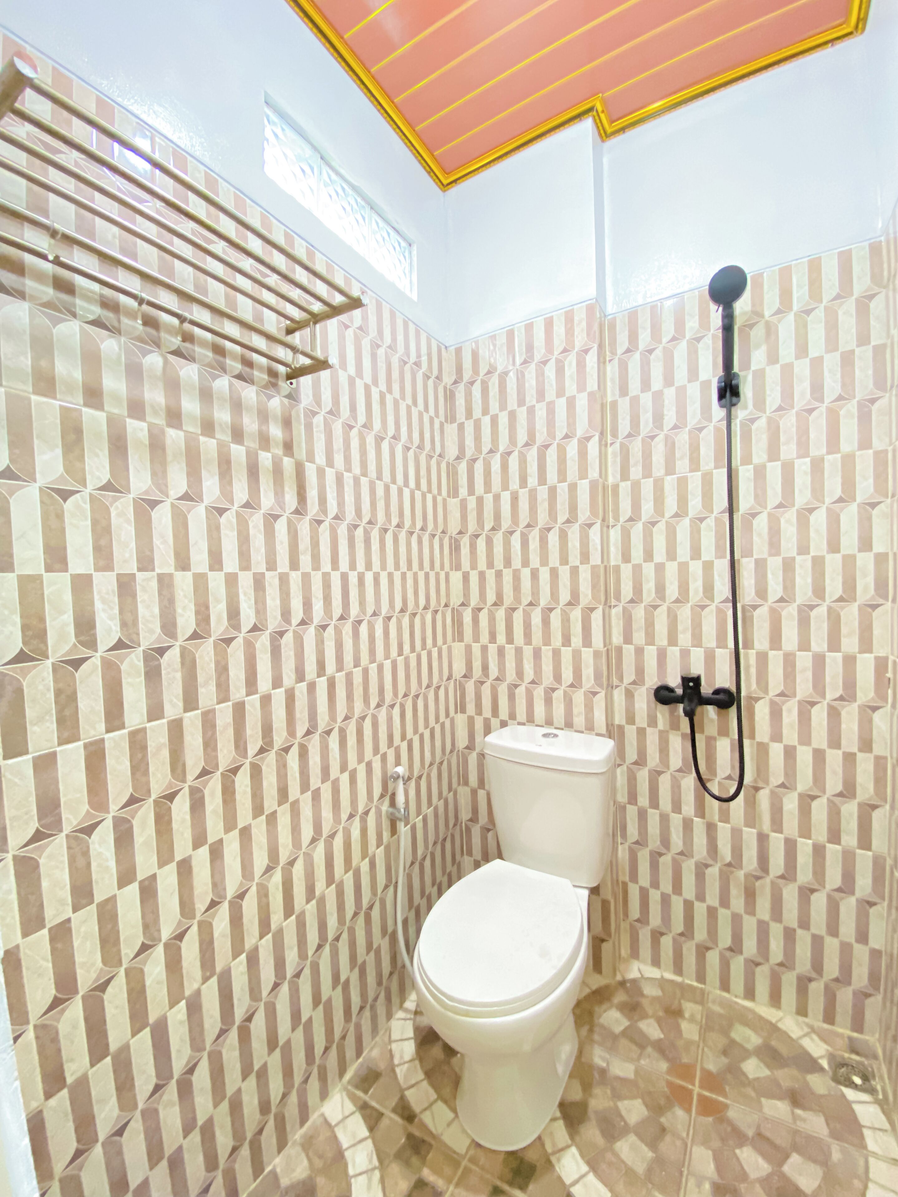 Ein Badezimmer mit Schachbrettfliesen, einer Toilette, einer Dusche und einem Handtuchhalter.