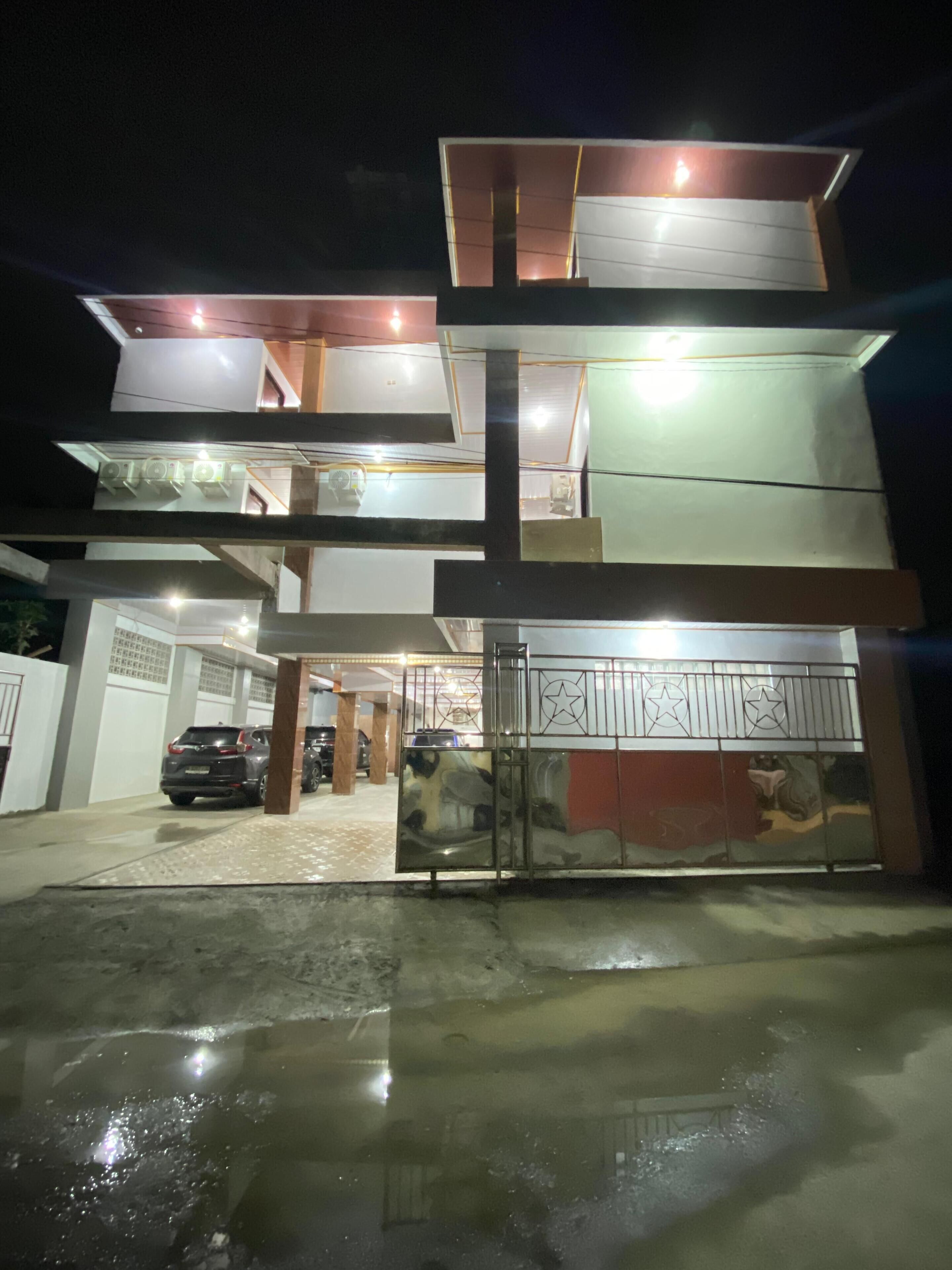 A multi-story building with a gated entrance and a car parked inside.