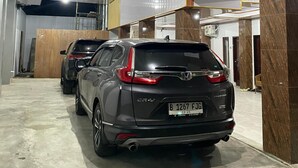 A modern indoor parking garage with polished concrete floors and marble walls. - d'WF Hotel (Kalasan)