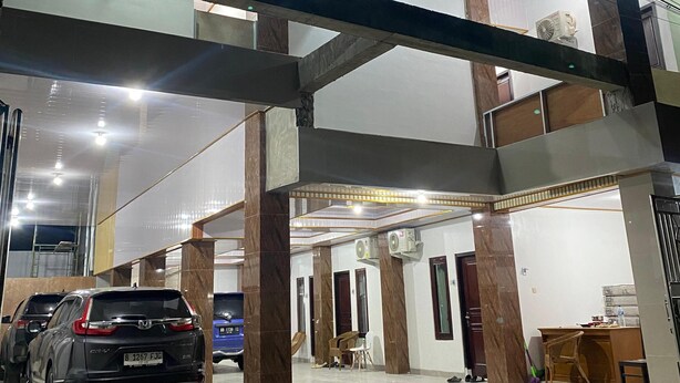 A multi-level parking garage with several cars parked. - d'WF Hotel (Kalasan)