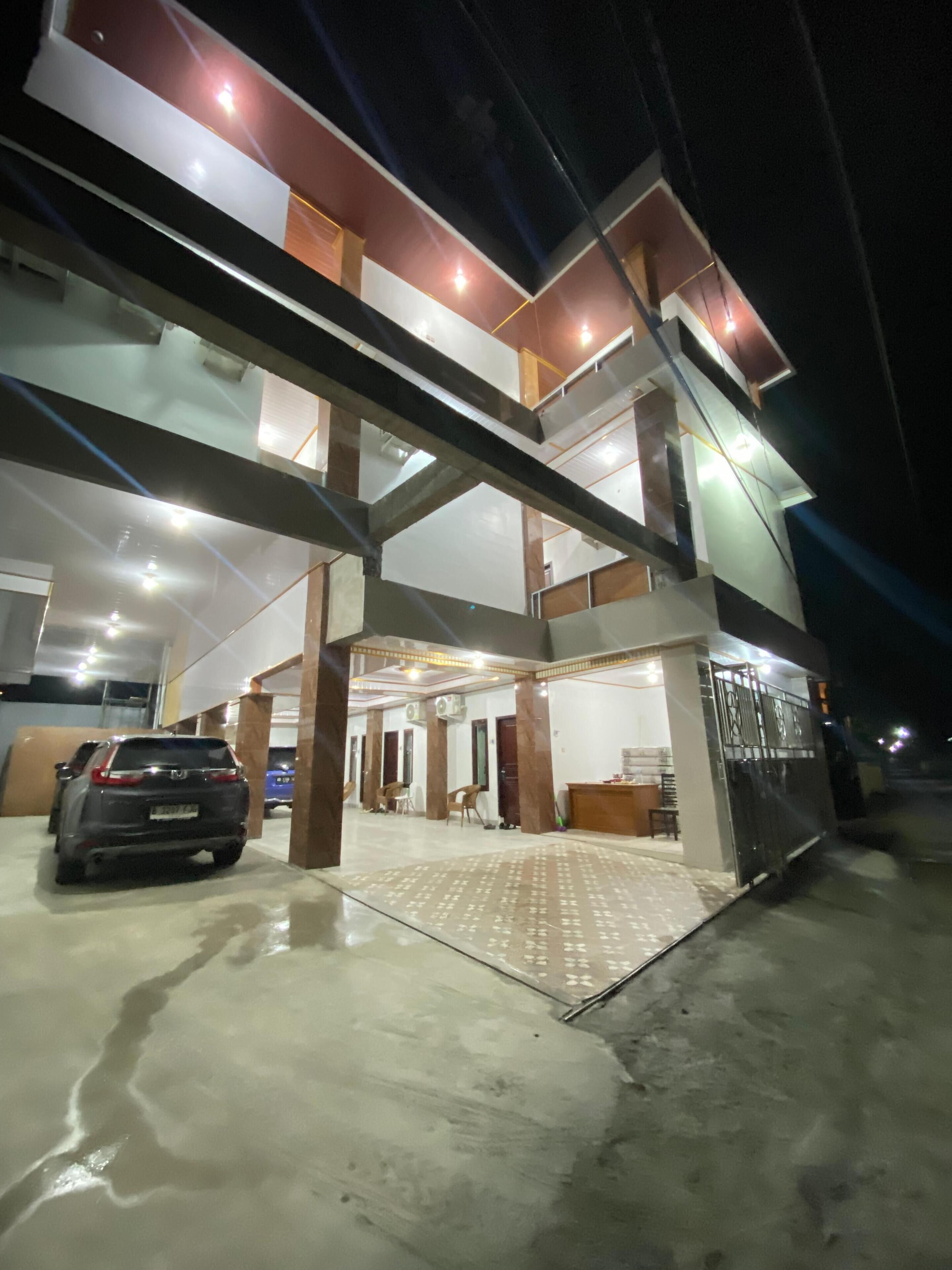 A multi-level building with a parking area, a reception desk, and a seating area.