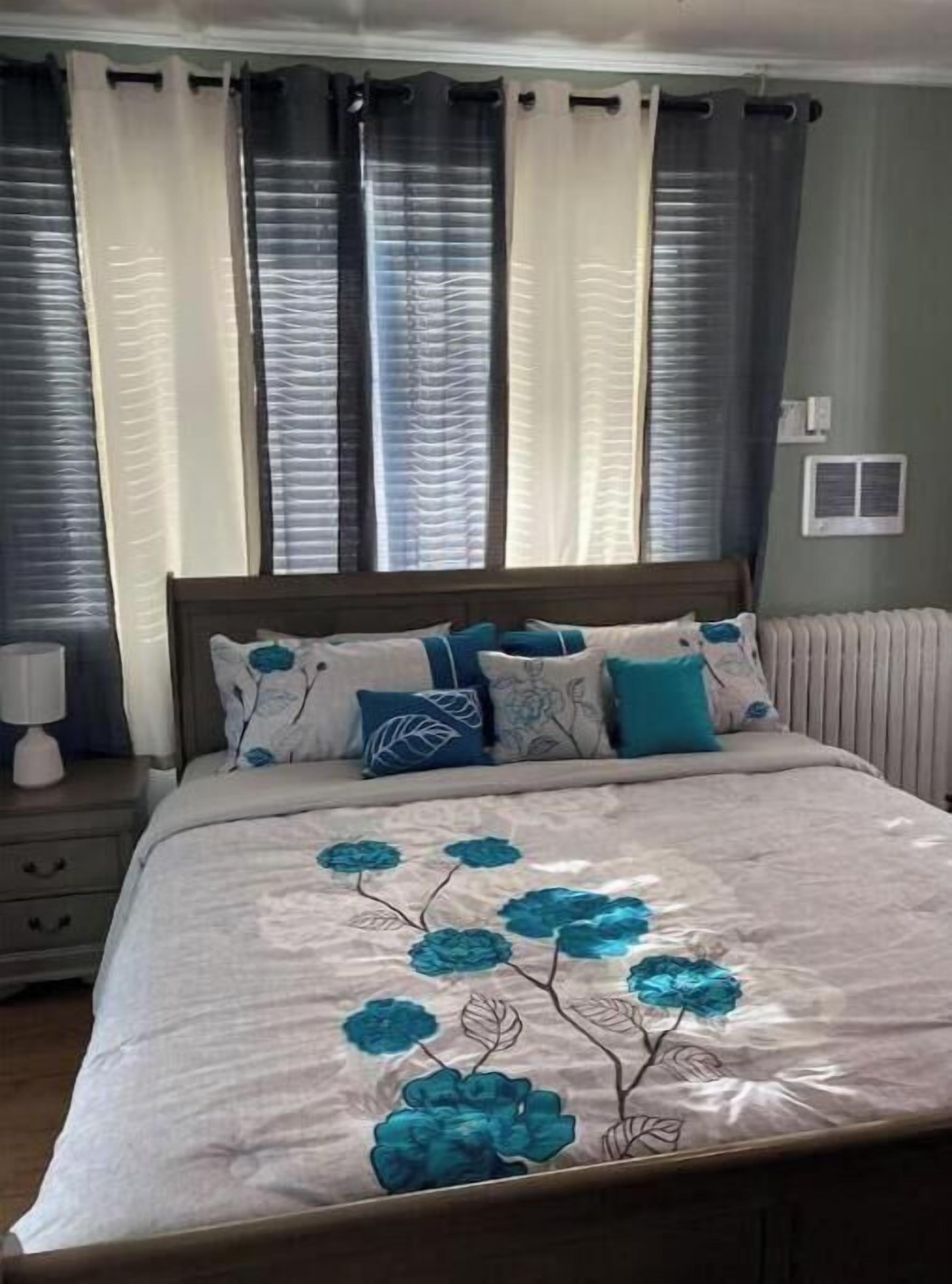 A bedroom with a bed, nightstands, and a window with curtains.