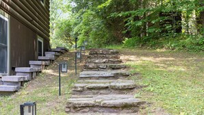 A stone staircase leading to a wooden building, surrounded by greenery. - Waterfront retreat with fireplace 3 miles from Whiteface & The North Pole (Wilmington)