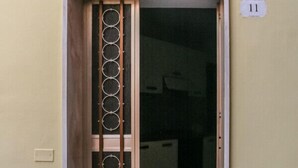 A door with a metal grille and a welcome sign inside. - Brothers Home: Italian Vacation (Civitella Casanova)