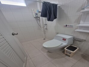 A small, clean bathroom with a toilet, a shower, and a trash bin. - Patamanan Residence Ang Thong (Wiset Chai Chan)