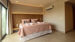 Ein modernes Schlafzimmer mit einem großen Bett, einem hölzernen Kopfteil und einer Klimaanlage an der Wand.