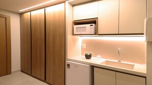 Eine moderne Küche mit Holzschränken, einer Mikrowelle, einem Spülbecken und einem Geschirrspüler.