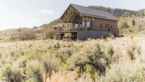 A rustic cabin with a balcony, surrounded by a natural landscape. - Modern Cabin at Blue Mesa, INCREDIBLE VIEWS, 40min from BLK CNYN (Gunnison)