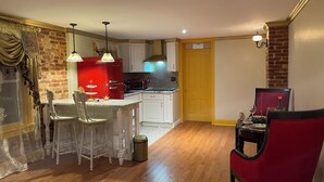 A compact kitchen with a red refrigerator, white cabinets, and a wooden floor. - Step back in time and experience the elegance of Victorian era.  (Reading)