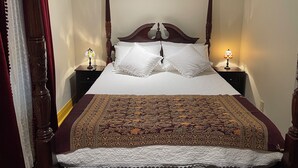 A four-poster bed with white linens and a patterned bedspread. There are two bedside tables with lamps. - Step back in time and experience the elegance of Victorian era.  (Reading)