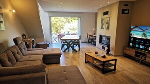 A modern living room with a sectional sofa, a coffee table, a TV, and a fireplace.