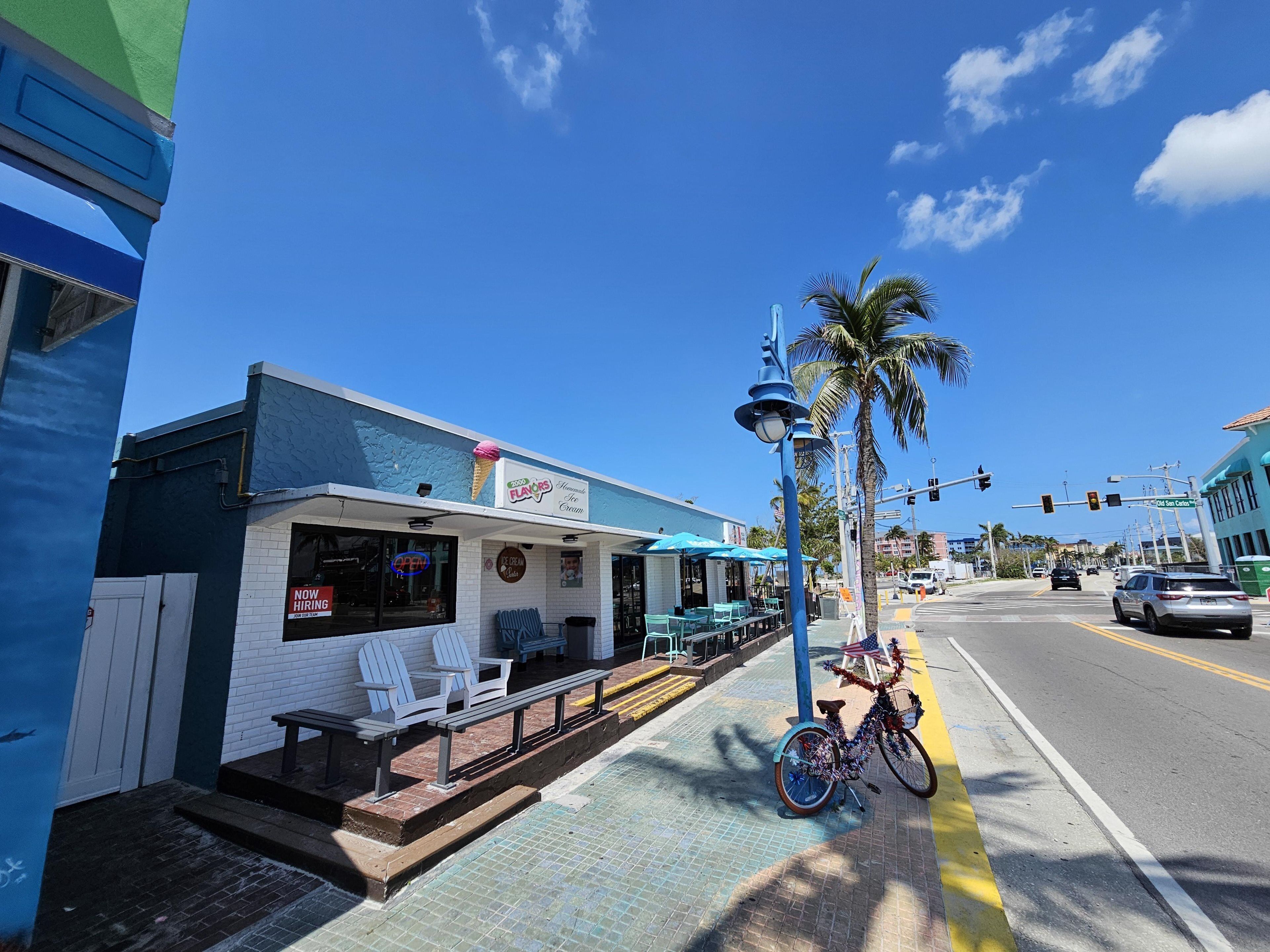 Un petit magasin de glaces avec une terrasse et un vélo garé devant.