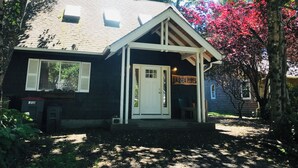 A small, two-story building with a dark exterior and white trim, a front porch, and a sign that reads "SEA PINE." - Sea Pines -dog friendly-Spacious and family Friendly-Secluded (Cannon Beach)