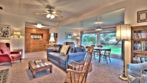 A spacious living room with a fireplace, a dining area, and a bookshelf.