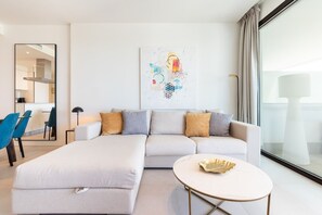Ein modernes Wohnzimmer mit einer Couch, einem Couchtisch und einem Gemälde an der Wand.