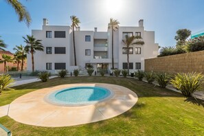 Un edificio moderno de varios pisos con una piscina al frente.
