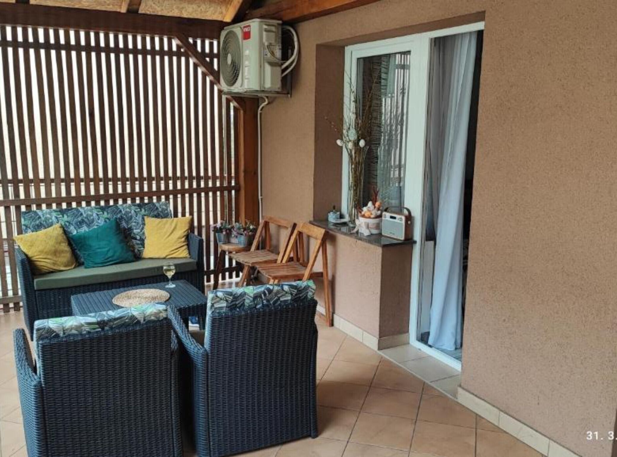 A cozy outdoor seating area with wicker furniture, a small table, and a bar area with a radio.