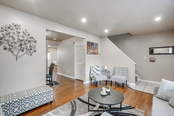 A spacious living area with a modern design, featuring a sofa set, a coffee table, and a decorative wall piece. - Walk to Mall & Train Station! Philly Suburb Stay (Willow Grove)