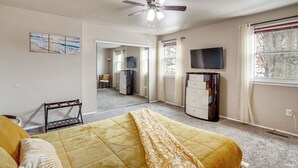 A bedroom with a bed, a ceiling fan, a TV, and a window with curtains. - Walk to Mall & Train Station! Philly Suburb Stay (Willow Grove)