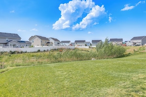 Houses with pitched roofs and a mix of siding and brick exteriors line a grassy area.