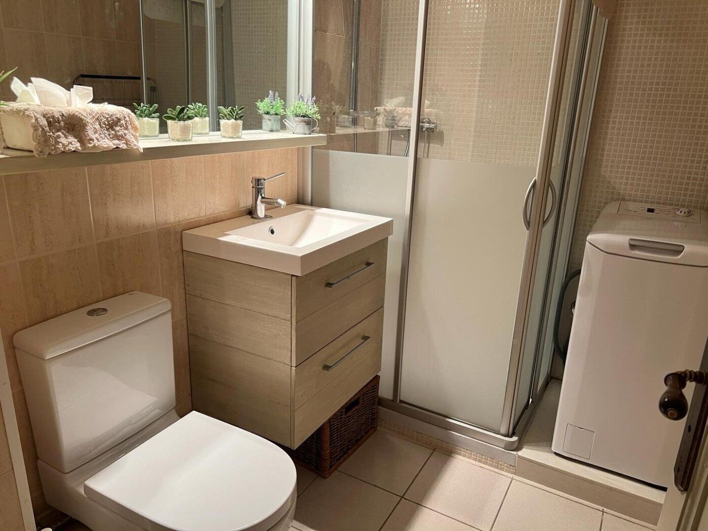 A modern bathroom with a toilet, sink, and shower.