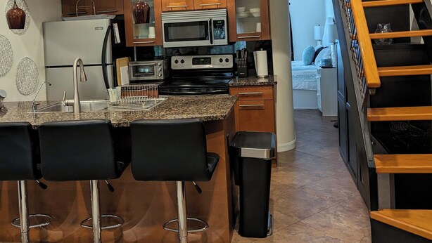 Une cuisine moderne dotée d’un îlot central, d’un four à micro-ondes, d’une cuisinière et d’un évier.