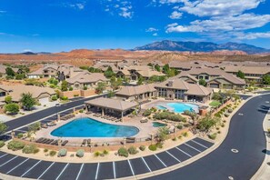 Zona residenziale con diverse case, una piscina e montagne sullo sfondo.