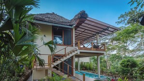 Uma casa moderna com piscina, rodeada por vegetação exuberante.