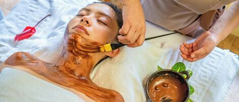 A person receiving a facial treatment with a mask applied to their face.