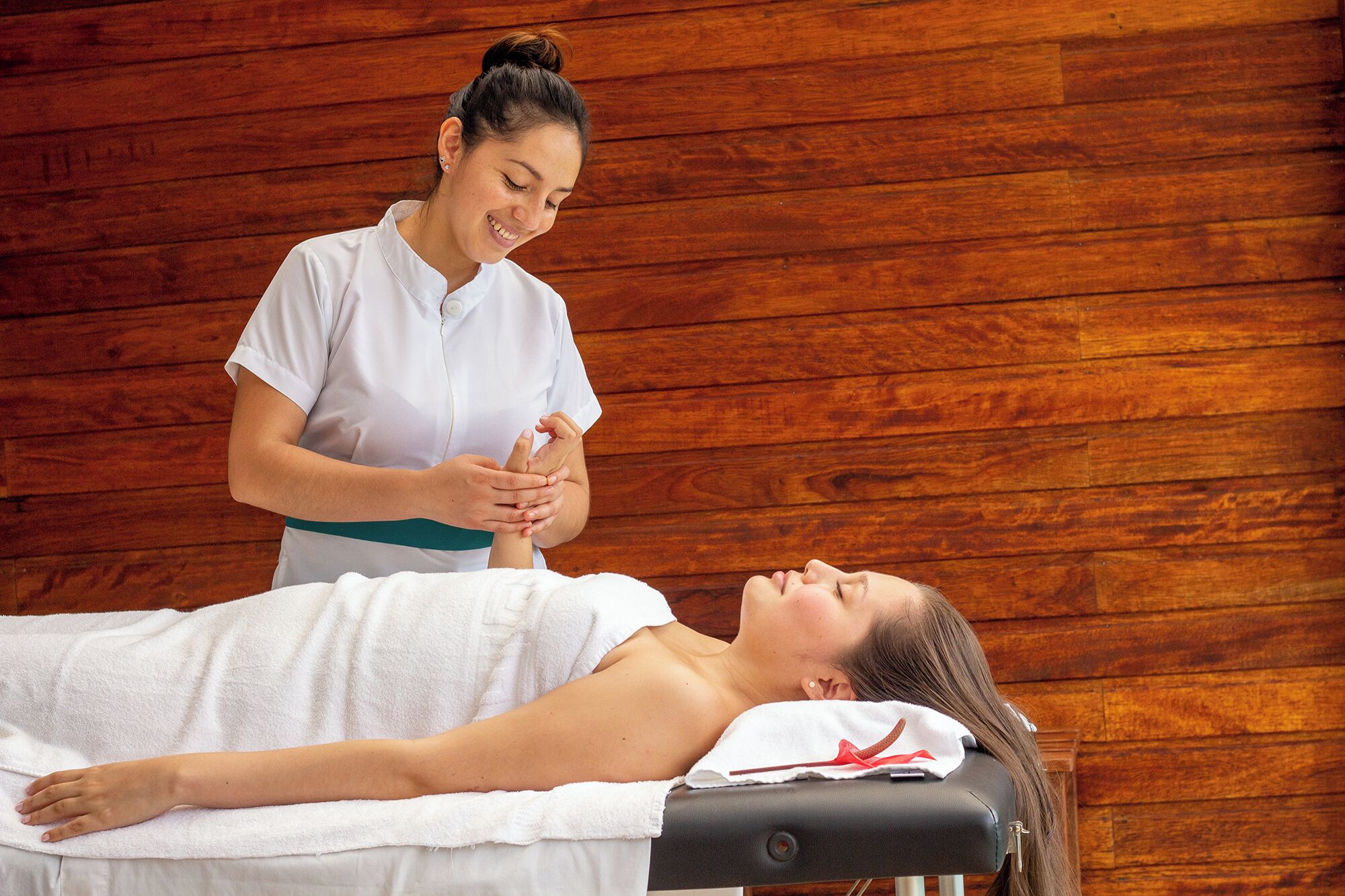 A person lying on a massage table receiving a treatment.