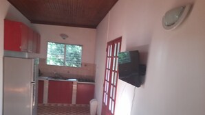 A compact kitchen with a refrigerator, a sink, and a window.
