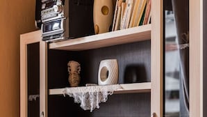 Et moderne tv-møbel med fladskærms-tv, træhylder og pyngeting.