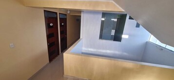 Un interior moderno con techo inclinado, un ventanal pequeño y una puerta con placa de número.