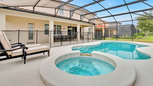 Ein überdachter Poolbereich im Freien mit Liegestühlen und einem Gewächshaus.