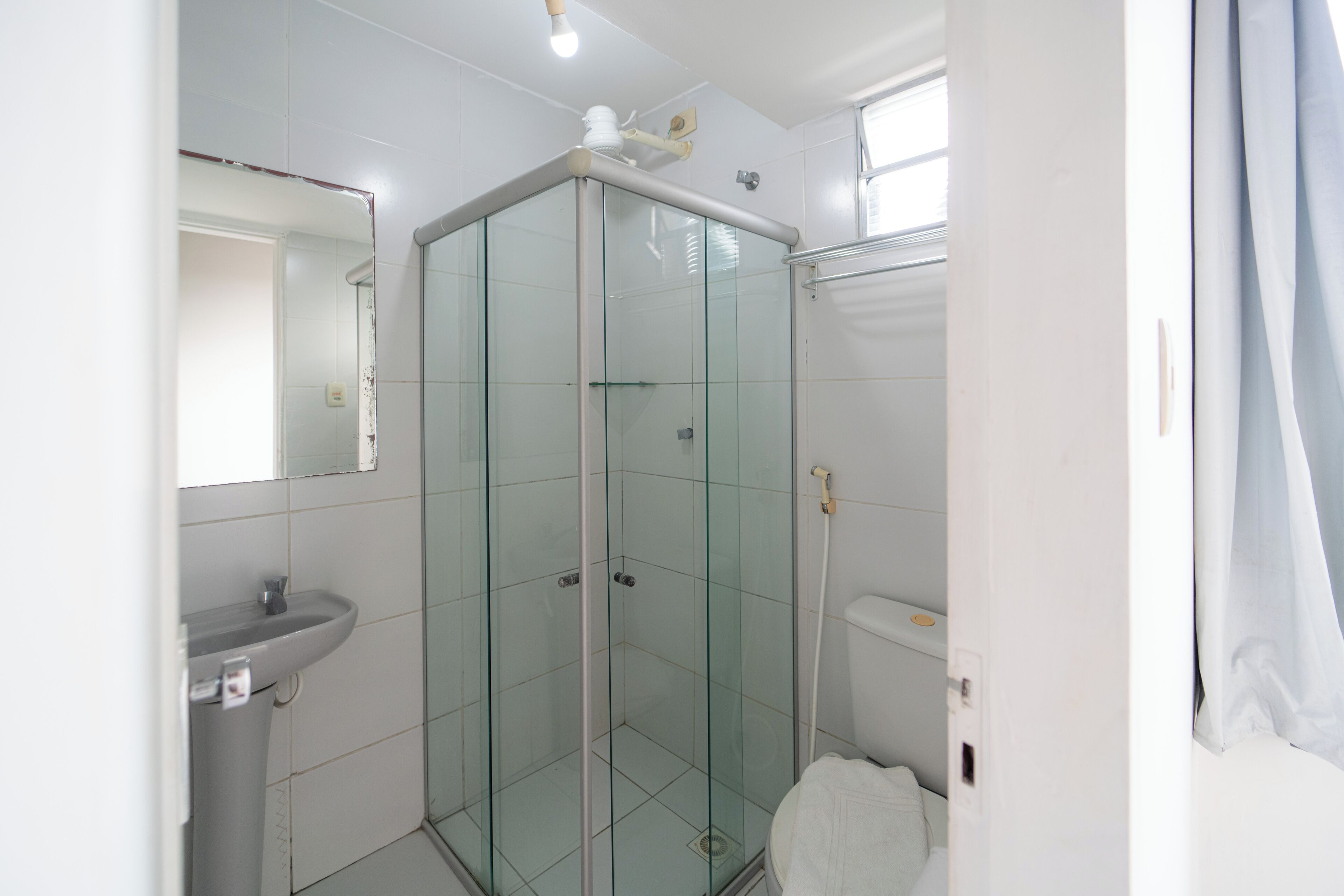 Ein modernes Badezimmer mit einer Glasdusche, einem weißen Waschbecken und einer Toilette.