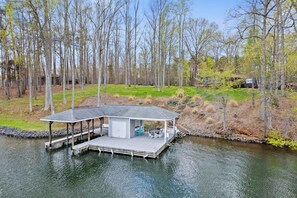 A lakeside cabin with a covered deck and outdoor seating area. - Lakefront Lake Anna with Views, Dock, Fire Pit (Bumpass)