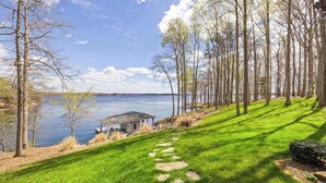 A grassy pathway leading to a lakeside property with a small gazebo and a dock. - Lakefront Lake Anna with Views, Dock, Fire Pit (Bumpass)