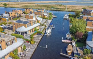 A canal-side residential area with modern houses, a dock with boats, and a clear view of the water. - 2 bedroom gorgeous home in Lemmer (Lemmer)