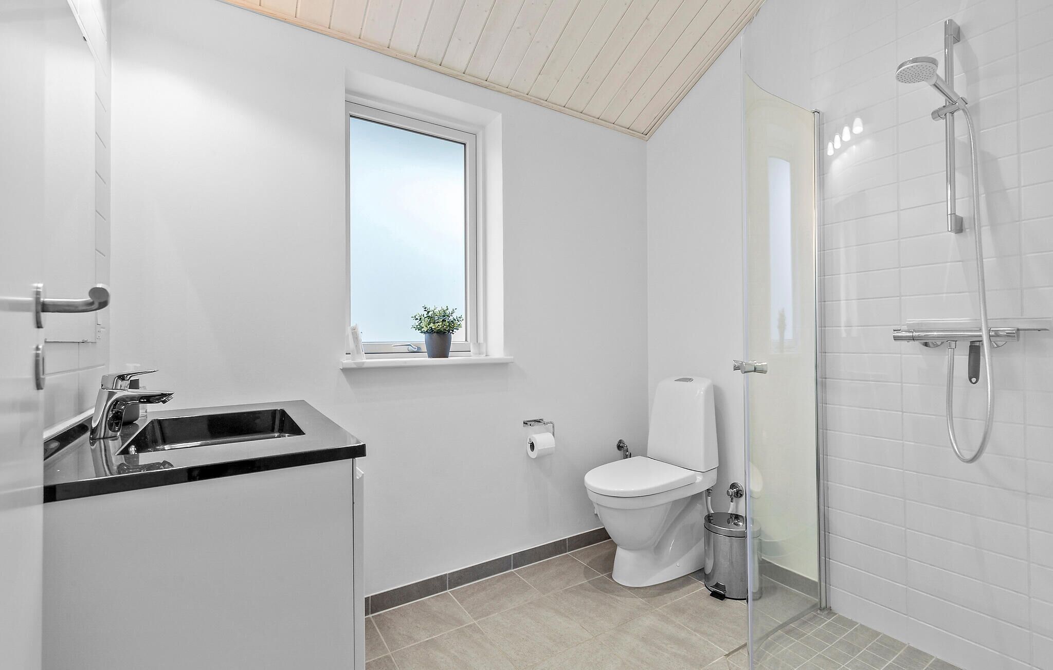 Une salle de bain moderne équipée de toilettes, d’un lavabo et d’une douche.